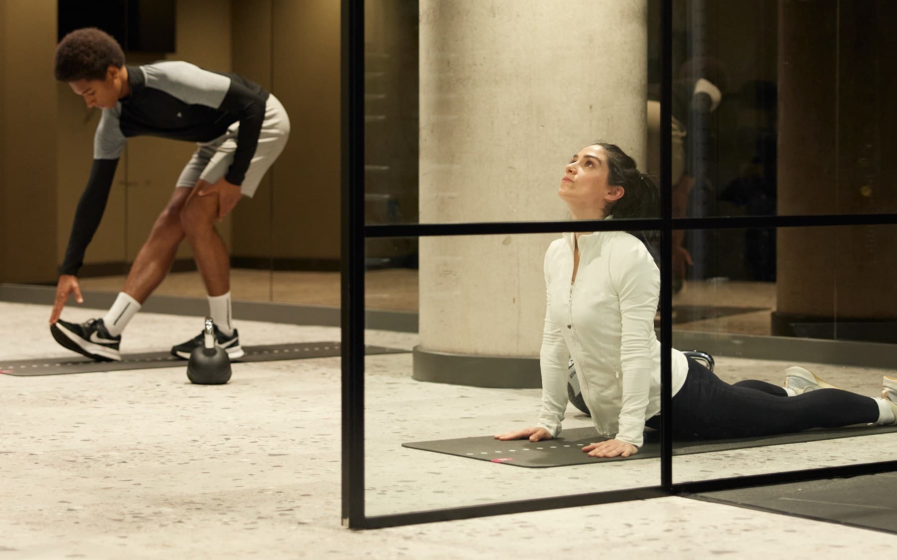 Two residents stretching in the communal fitness space